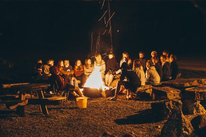 a group of people sitting around a campfire