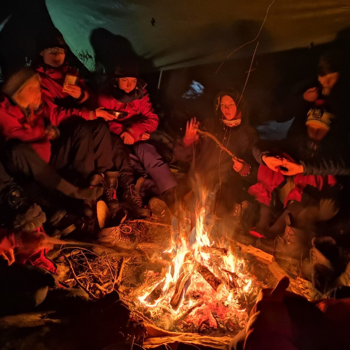 a group of people sitting around a fire